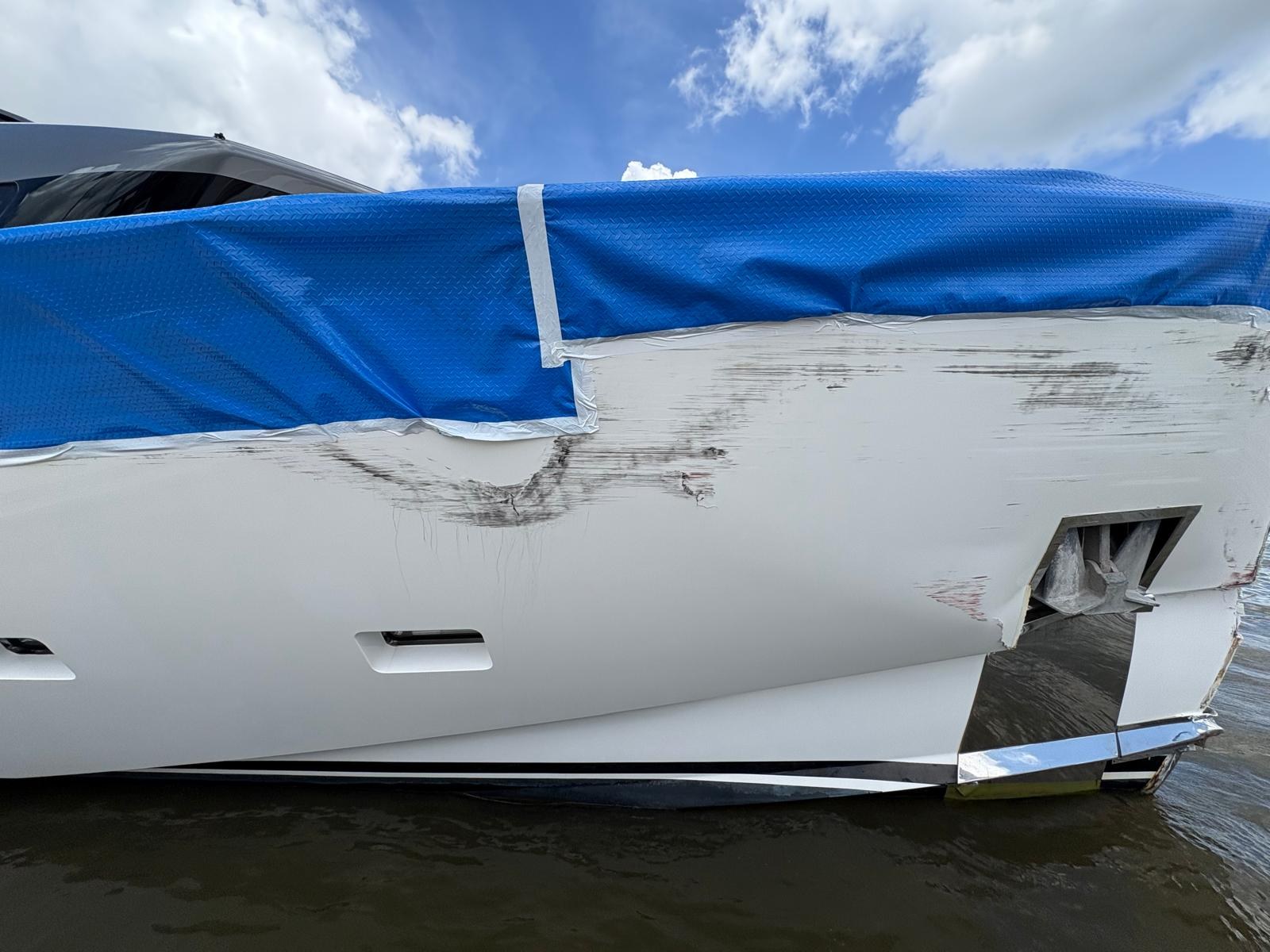 Severe impact damage to the side and stern quarter of a motor yacht