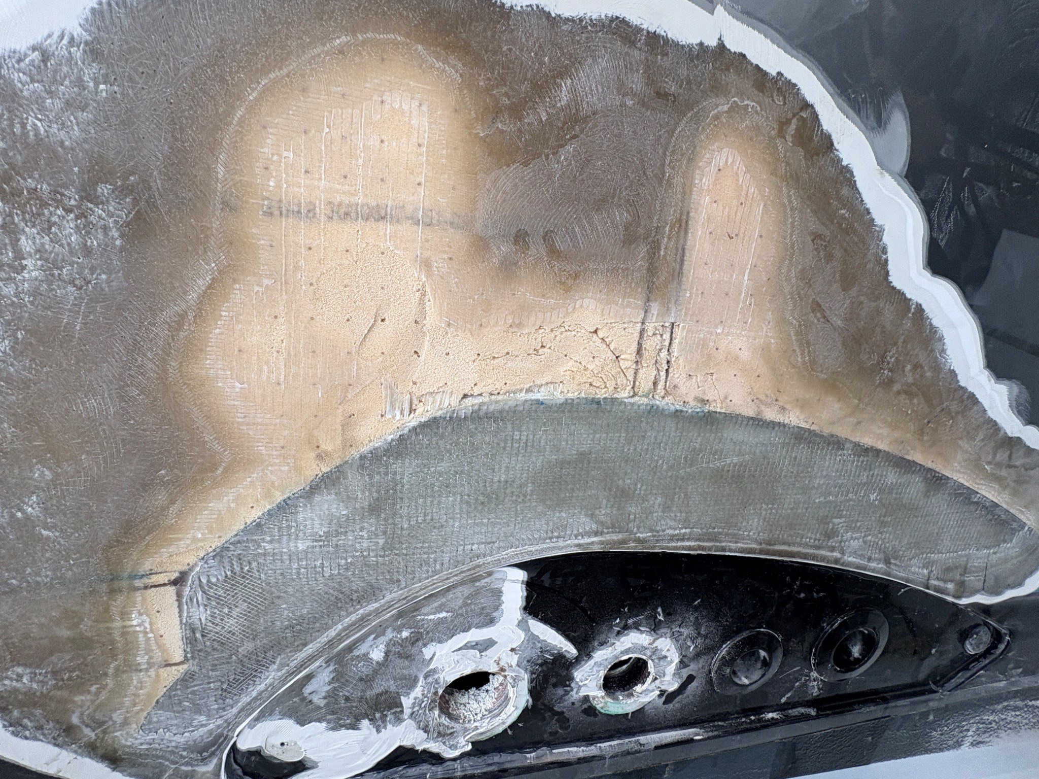 Composite yacht structure ground back to expose laminate and repair boundaries