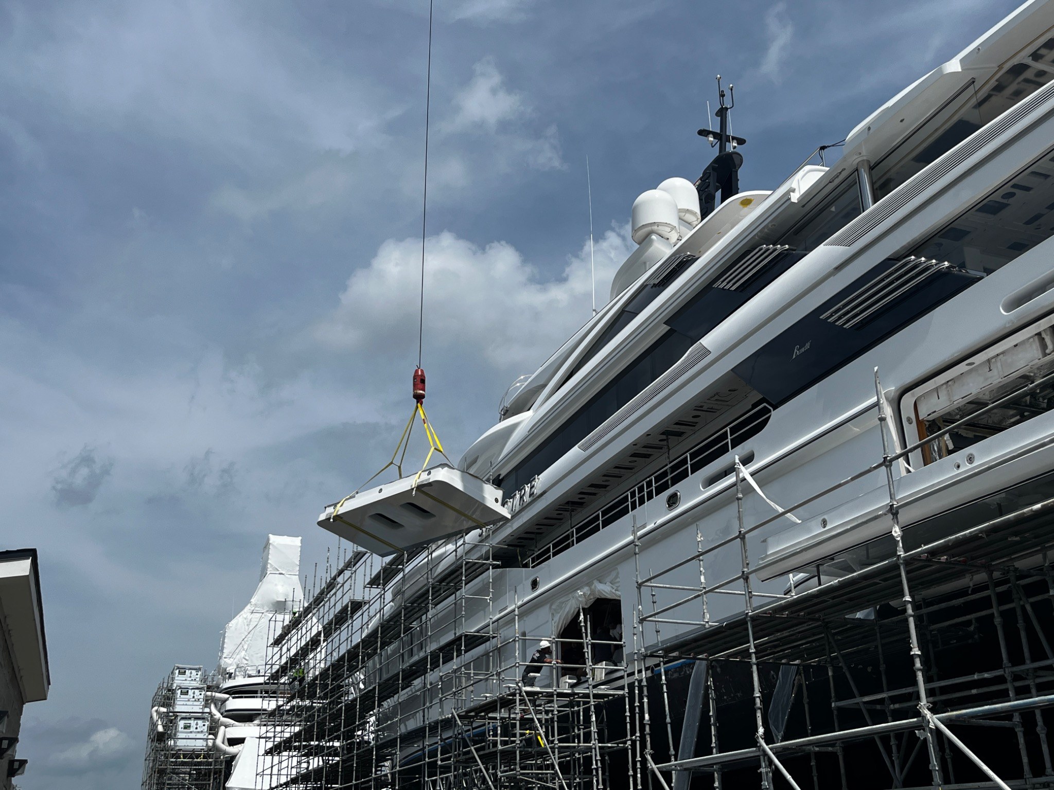 Large motor yacht under extensive scaffold during active refit work